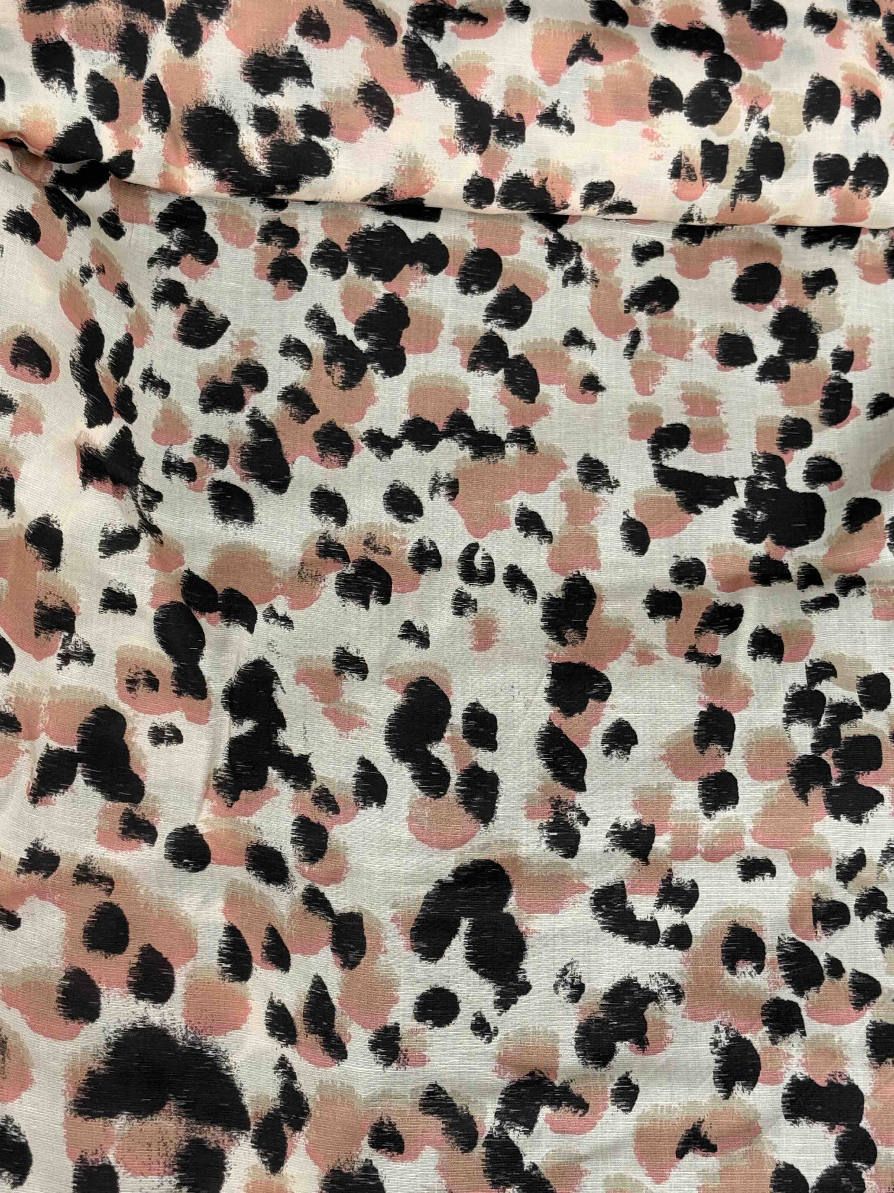 Linen Tencel blend, fabric with an animal style print - black, brown and pink spots on a cream background